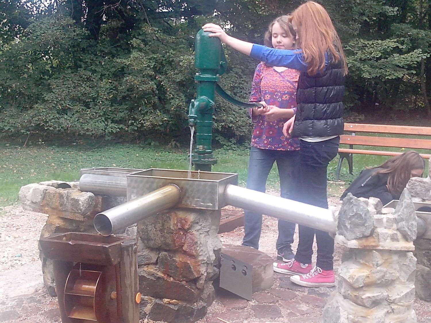 Zwei Mädchen an der Wasserpumpe auf dem Spielplatz Zweenfurth