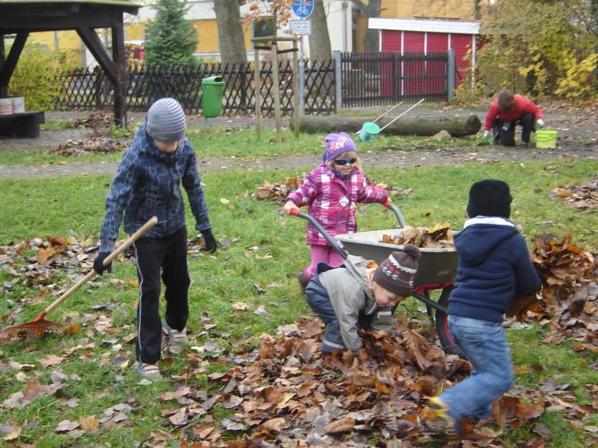 Kinder sammeln das Laub ein