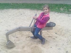 Mädchen auf Metallbagger - Spielplatz Zweenfurth